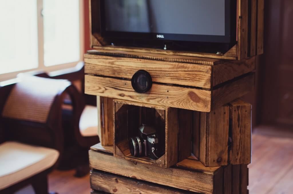 Close-up of the handcrafted wooden photo booth: wine crate front with lens and DSLR camera in its compartment